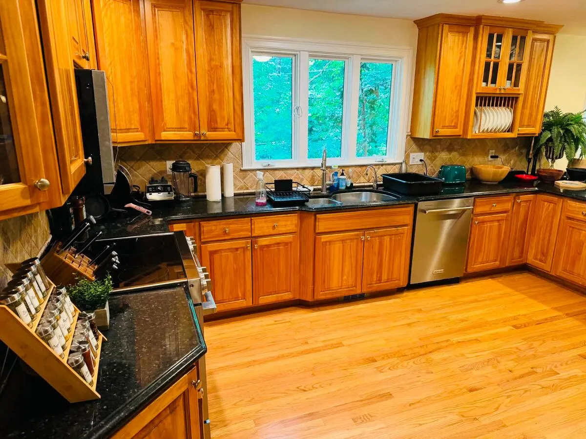 A warm wood kitchen with black counters and a pull-out spice rack